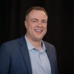 man in a black background looking at the camera