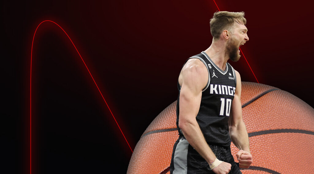 basketball player domantas sabonis screaming behind a basketball logo