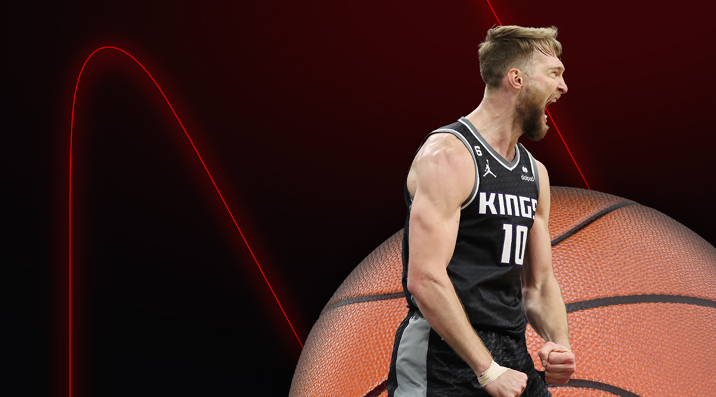 basketball player domantas sabonis screaming behind a basketball logo