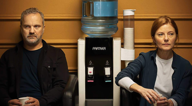 Lietuviško filmo „Paradas“ plakatas – vyras ir moteris tarp vandens aparato.<br> <br> <br>