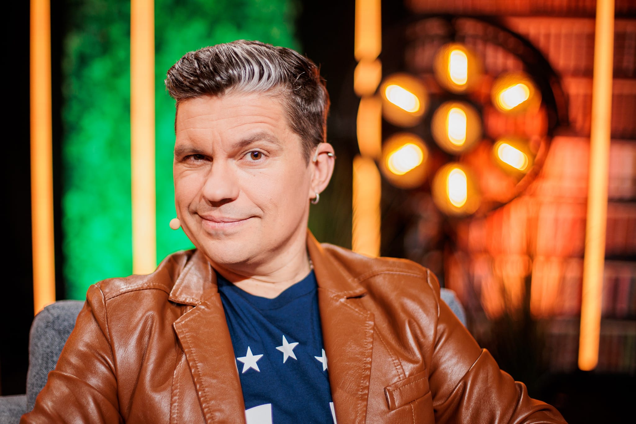 deividas norvilas aktorius ziurintis i kamera spalvotame fone