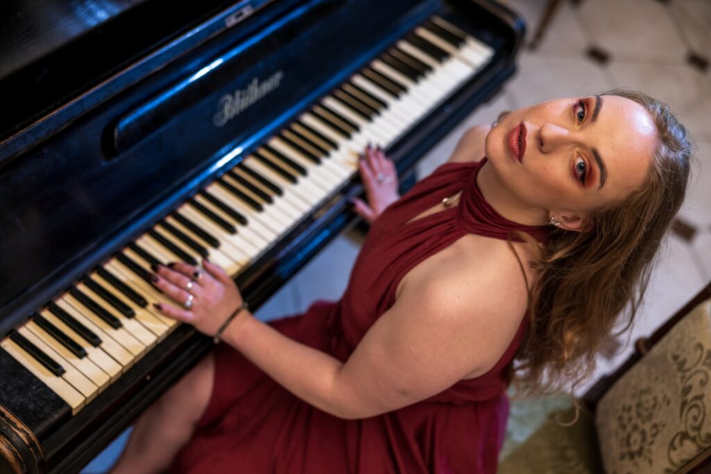 moteris su raudona sukneles groja pianinu