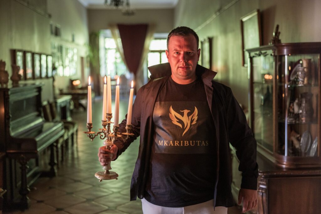 vyras su zvake tamsiame fone