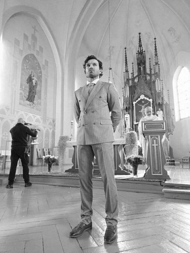 vyras stovintis baznycioje