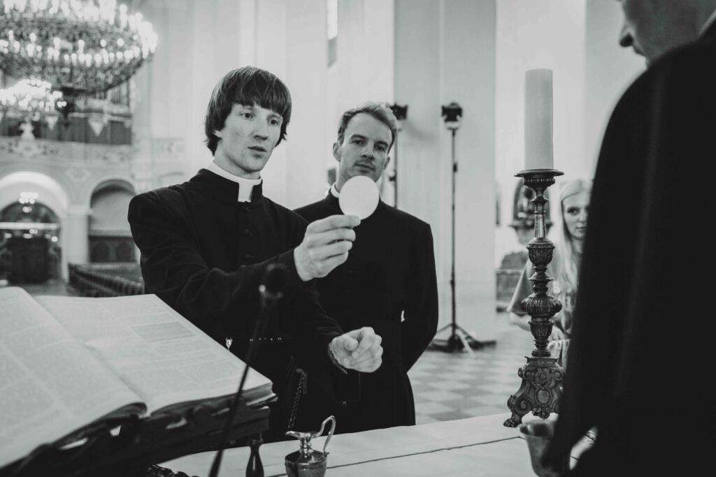 kunigai stovi bažnyčioje juodam baltam fone