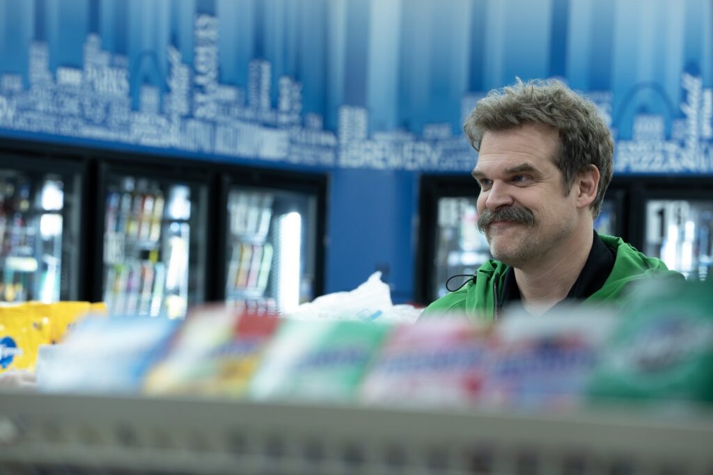 vyras su usais parduotuveje uz prekiu