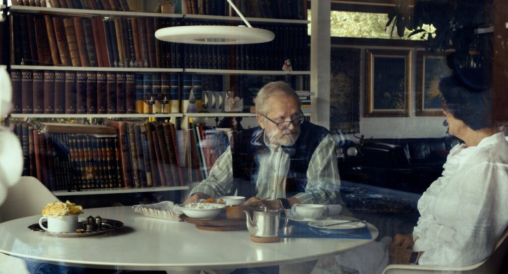 pagyvenęs vyras sėdi prie darbo stalo