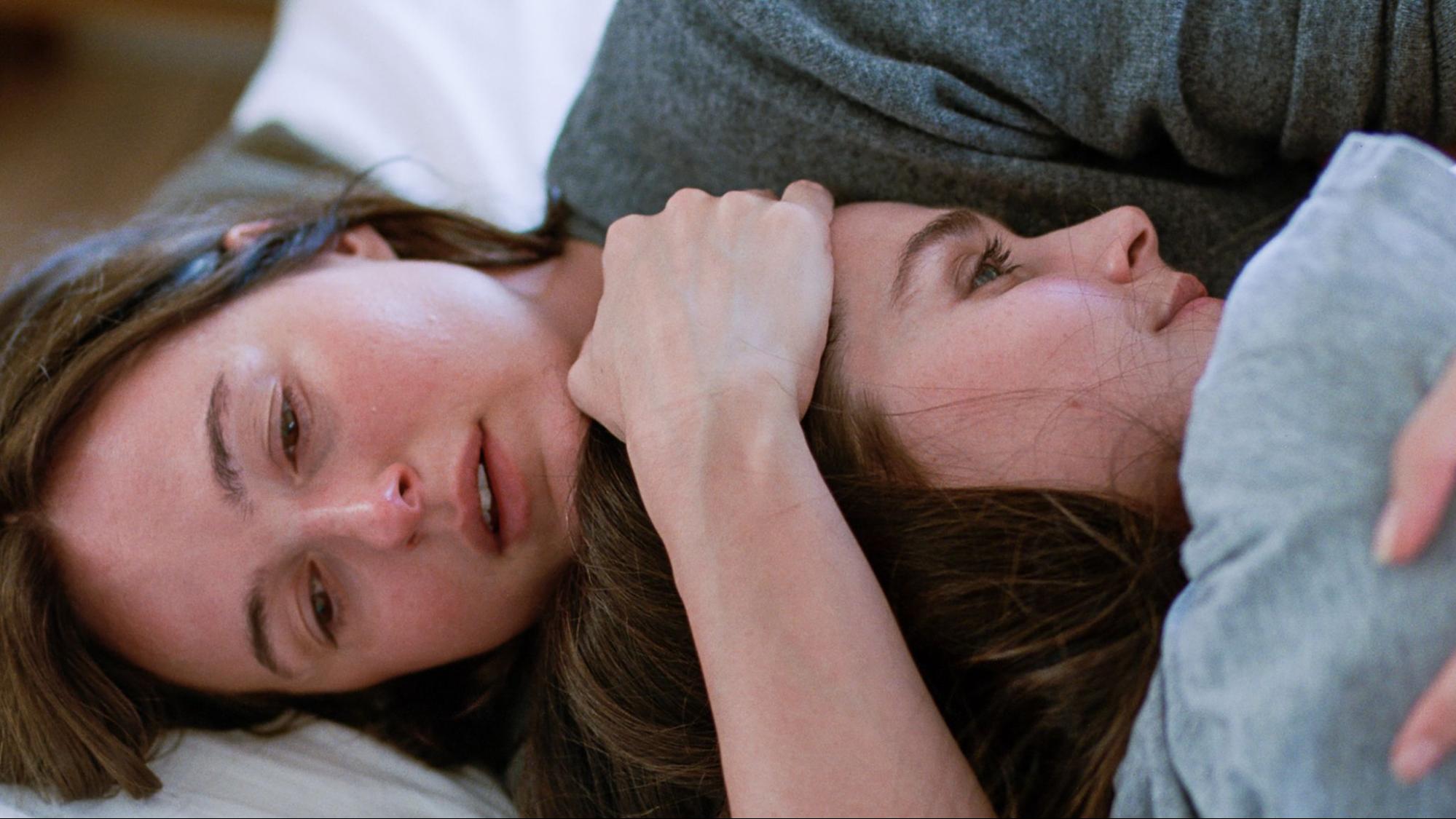 two woman laying and hugging each other