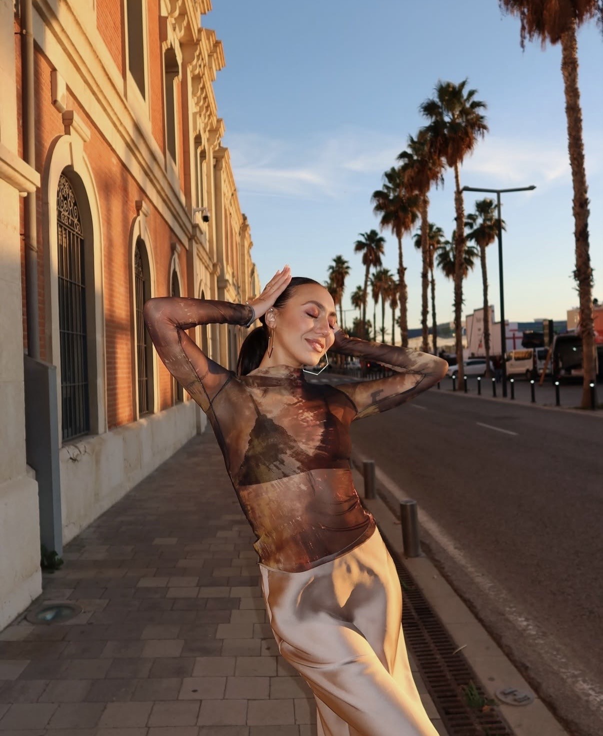 mergina pozuoja prie palmiu